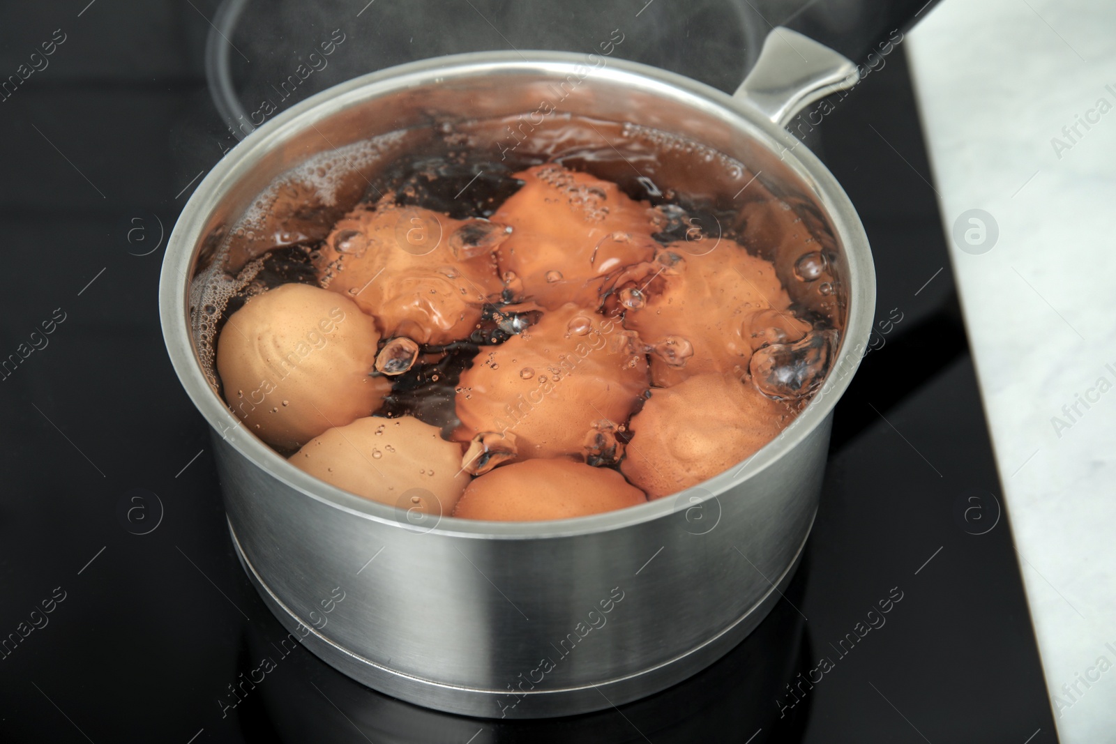 Photo of Boiling chicken eggs in saucepan on electric stove