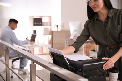 Photo of Employee using new modern printer in office