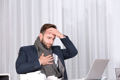Ill businessman suffering from cough in office