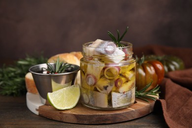 Tasty fish, onion, rosemary and marinade on wooden table, closeup