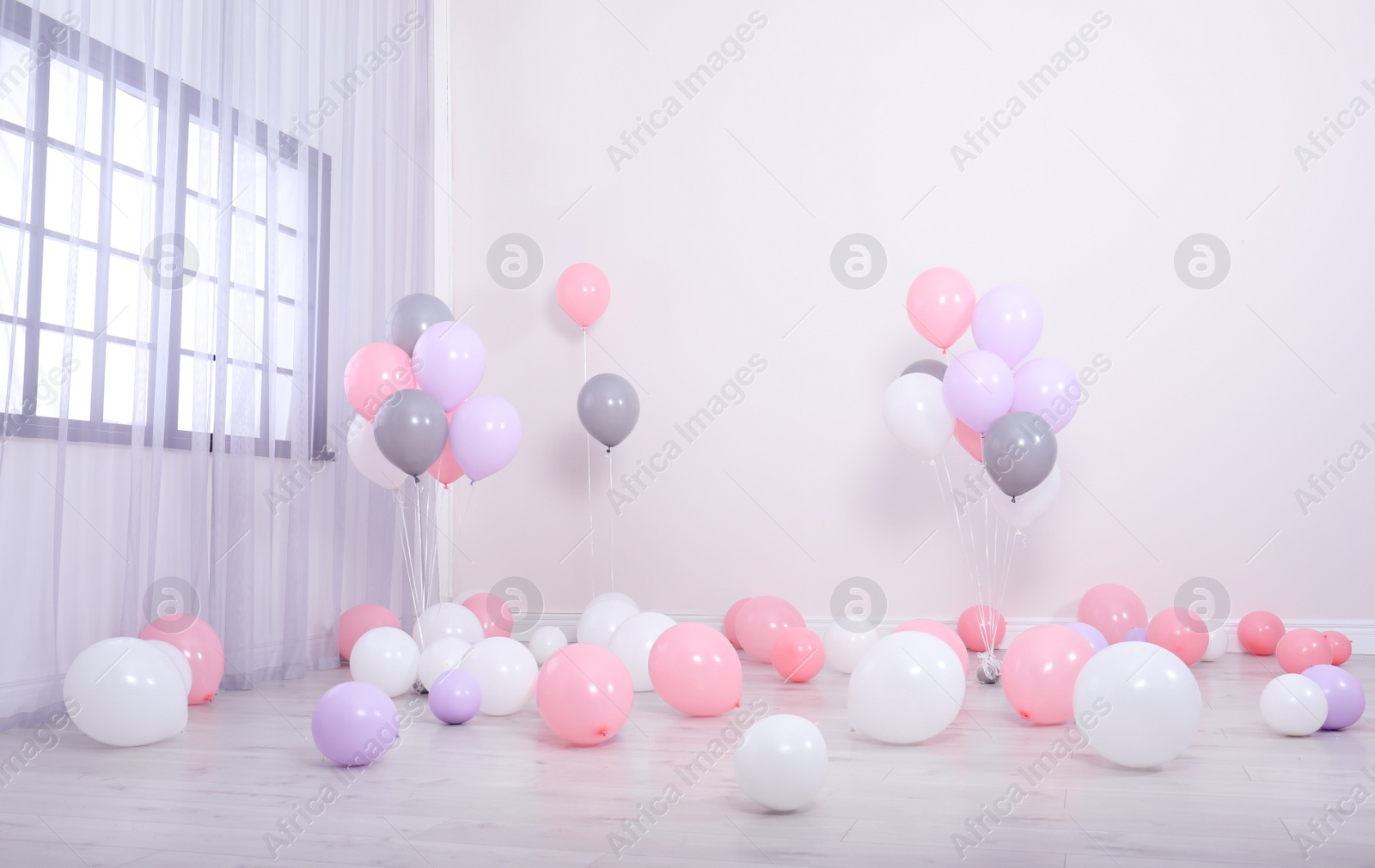 Photo of Room decorated with colorful balloons near wall