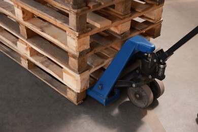 Image of Modern manual forklift with wooden pallets, closeup
