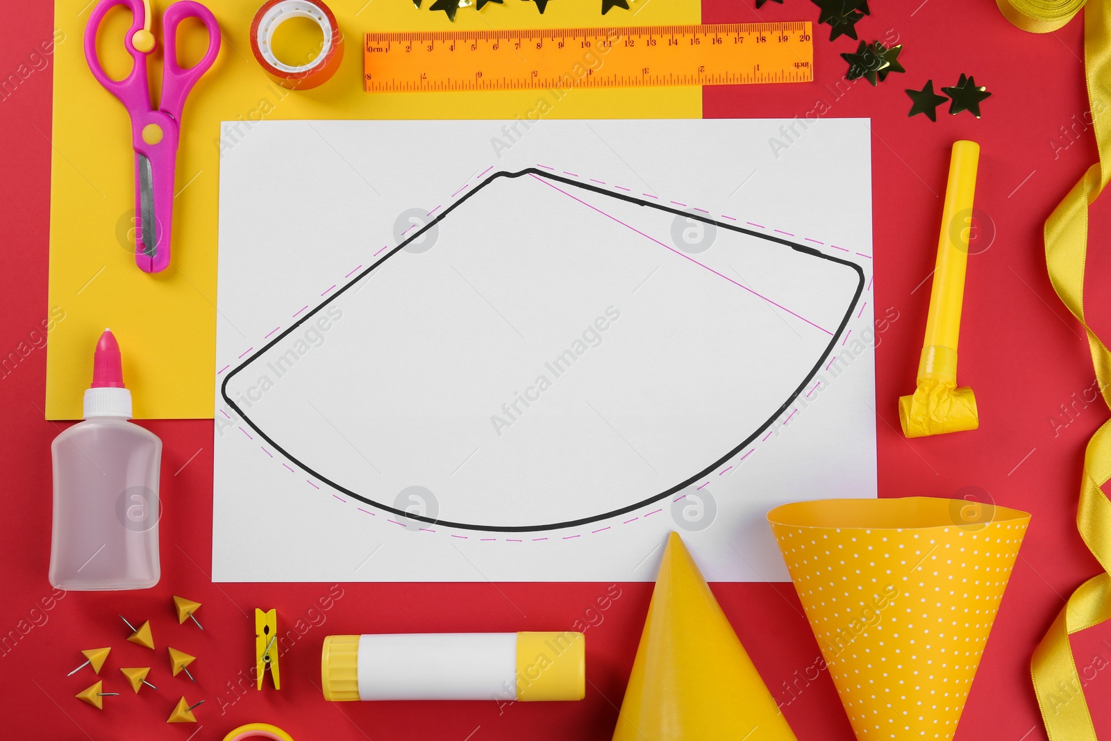 Photo of Handmade party hat template and supplies on red background, flat lay