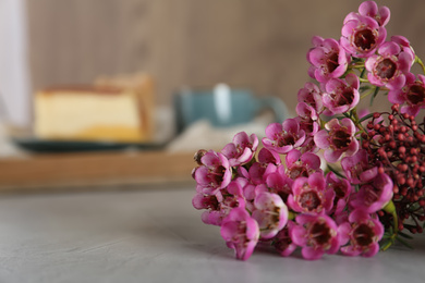 Photo of Bouquet of beautiful spring flowers on grey table, closeup. Space for text