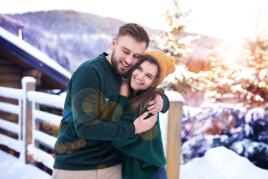 Lovely couple spending time together on snowy day. Winter vacation