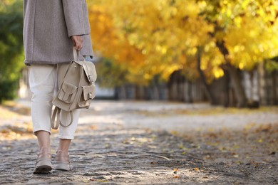 Photo of Young woman with stylish beige backpack on city street, closeup. Space for text