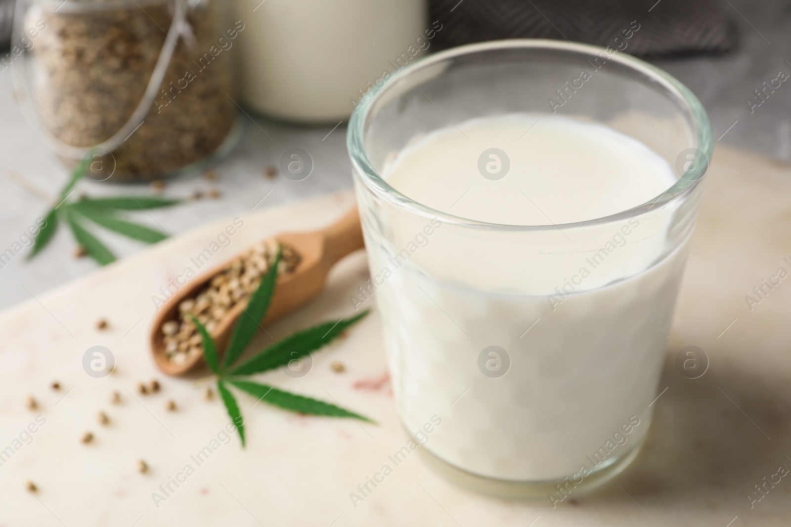 Photo of Composition with glass of hemp milk on light table, closeup. Space for text