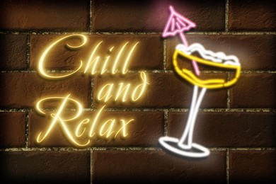 Image of Glowing neon sign with cocktail glass and phrase Chill And Relax on brick wall