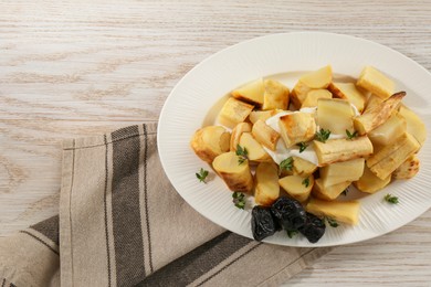 Photo of Tasty homemade parsnips with prunes and thyme on white wooden table, top view. Space for text