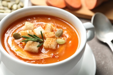 Bowl of tasty sweet potato soup on table, closeup. Space for text