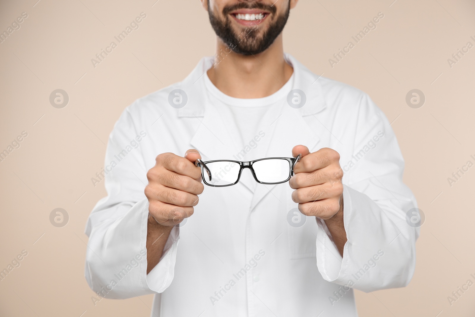 Photo of Male ophthalmologist with eyeglasses on light background, closeup