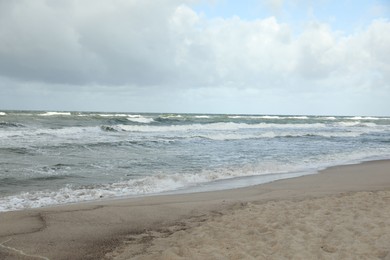 Picturesque view of wavy sea on cloudy day