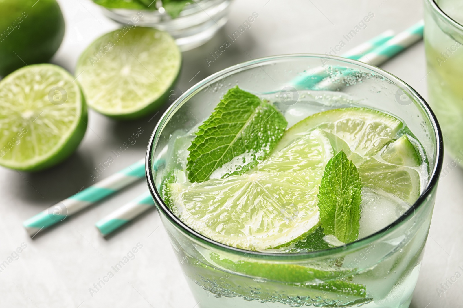 Photo of Refreshing beverage with mint and lime in glass on table, closeup