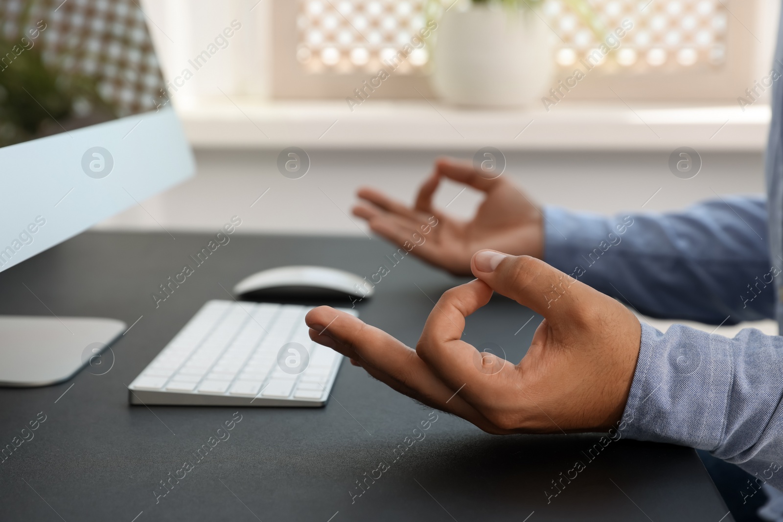 Photo of Businessman meditating at workplace, closeup. Zen concept