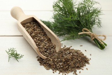 Photo of Dry seeds and fresh dill on white wooden table, closeup