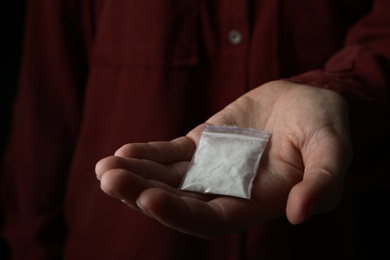 Photo of Drug dealer holding bag with cocaine, closeup