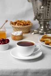 Aromatic tea, traditional Russian samovar and treats on table