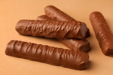 Photo of Sweet tasty chocolate bars on beige background, closeup
