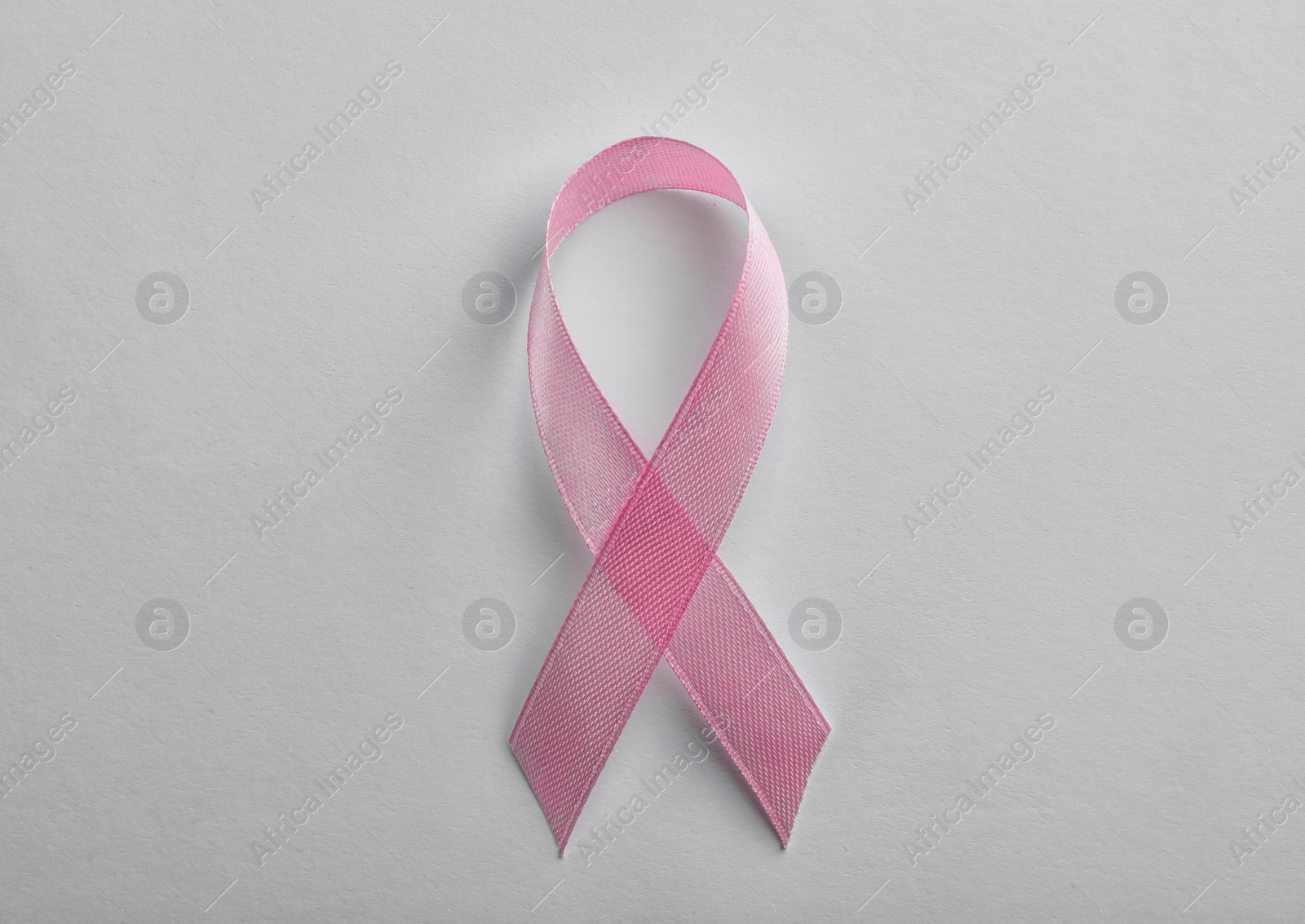 Photo of Pink ribbon on white background, top view. Breast cancer awareness concept