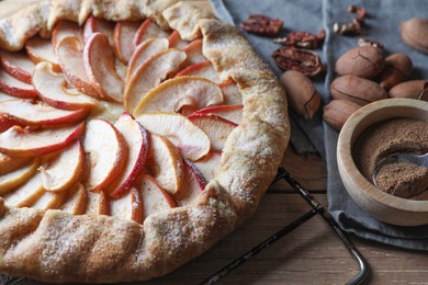 Delicious apple galette, cinnamon and pecans on table, closeup