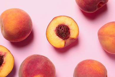 Cut and whole fresh ripe peaches on pink background, flat lay