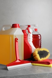 Photo of Car cleaning products and canister with motor oil on light grey table