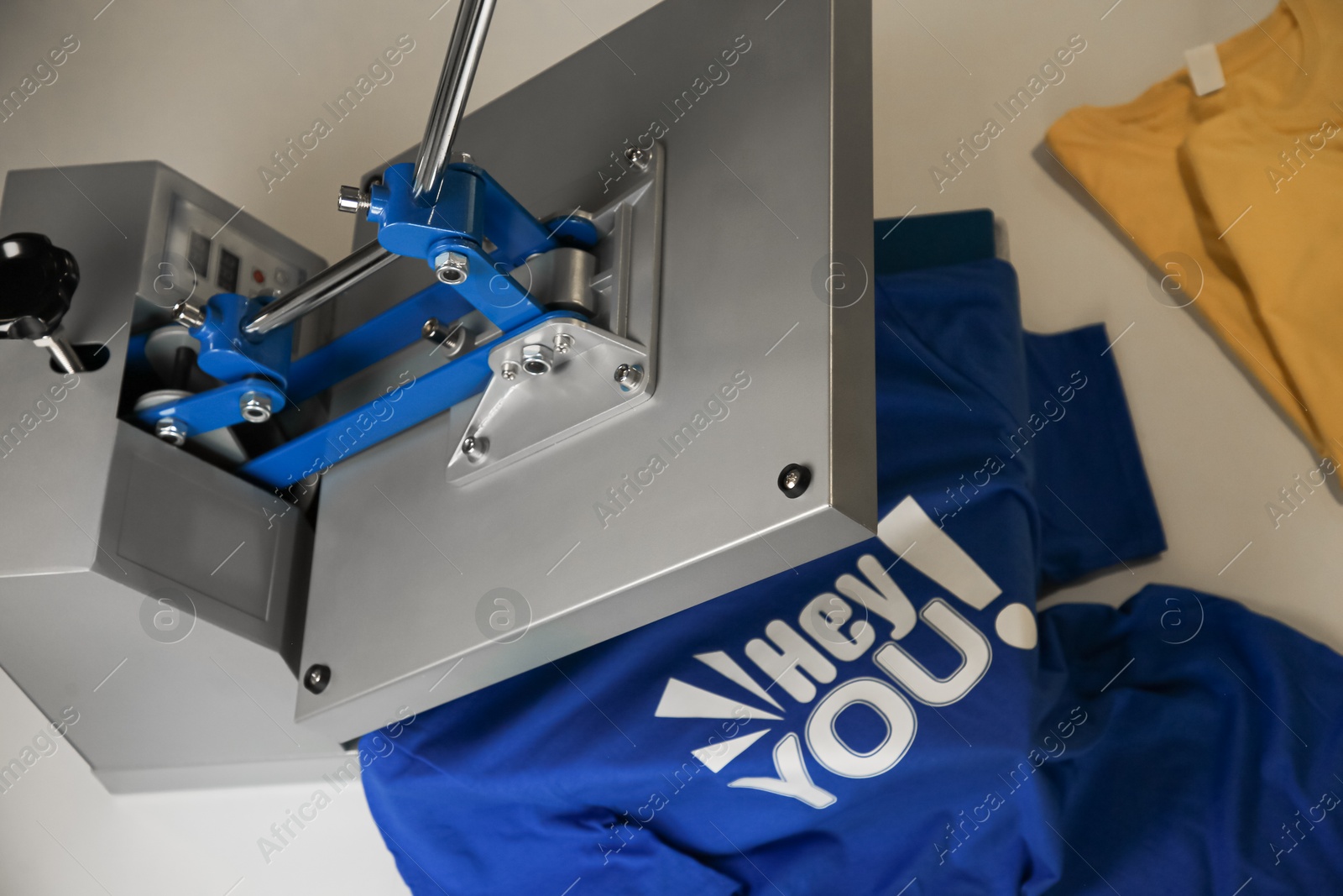 Photo of Printing logo. Heat press with t-shirt on white table