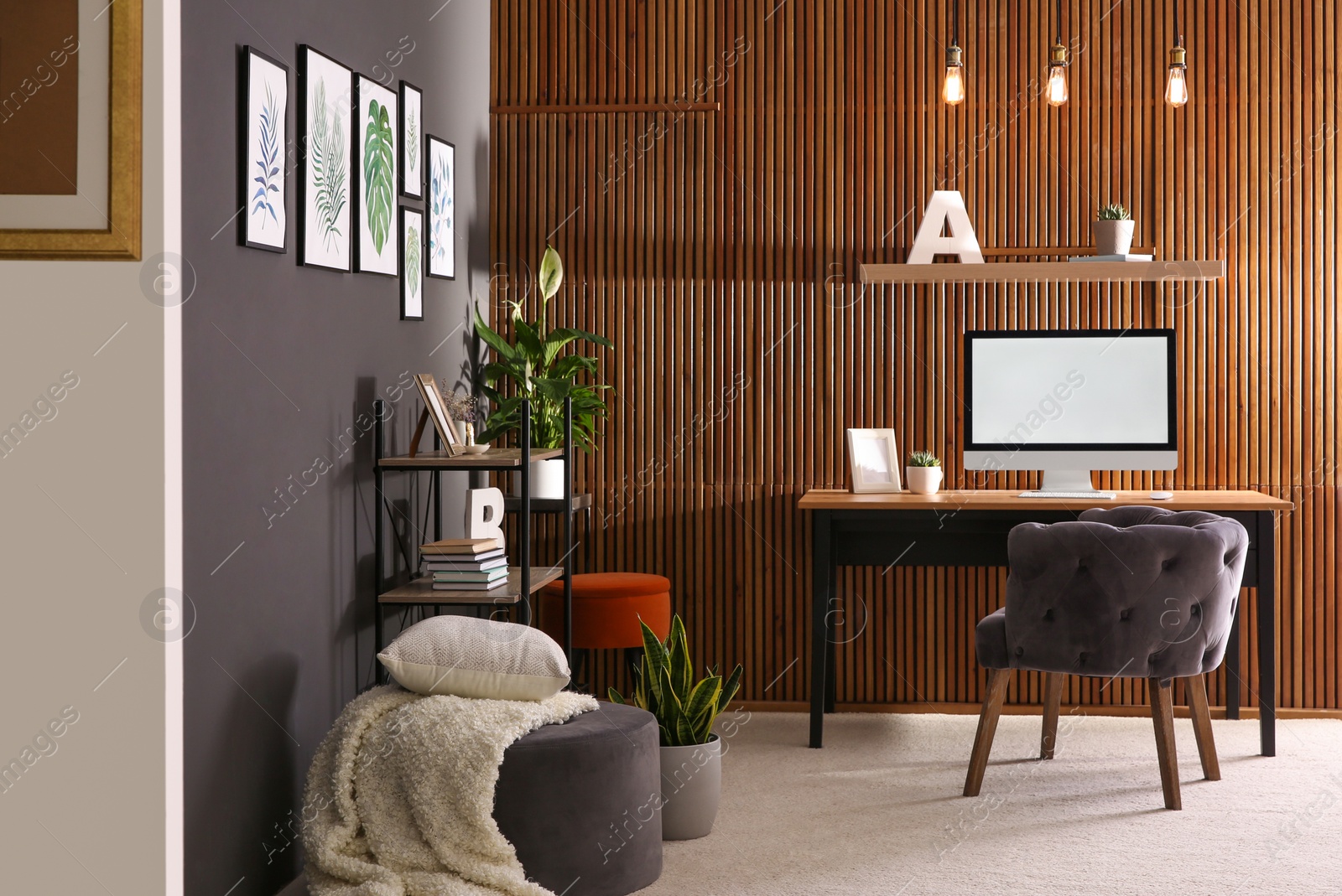 Photo of Comfortable workplace with computer near wooden wall in stylish room interior. Home office design