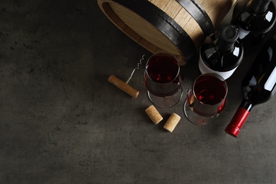 Photo of Flat lay composition with glasses and bottles of red wine on stone surface. Space for text