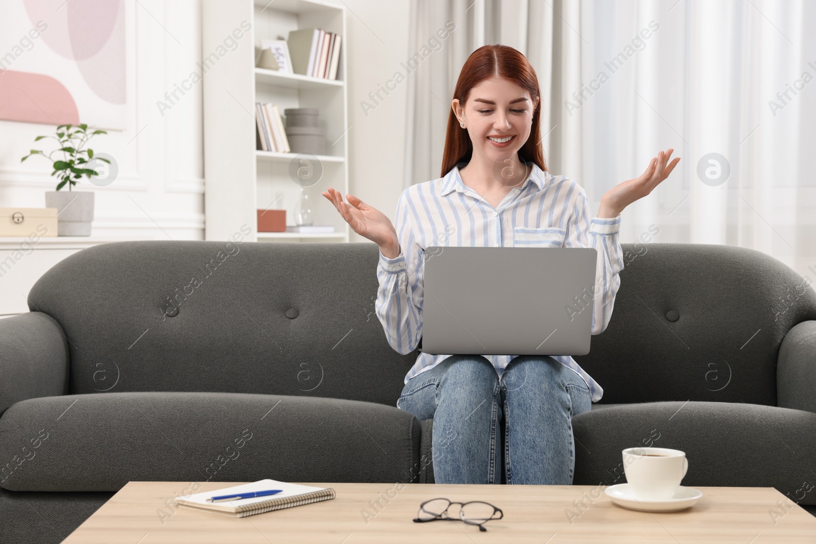 Photo of Happy woman with laptop having video chat in room