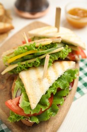 Photo of Delicious sandwiches with vegetables and cheese on white table, closeup