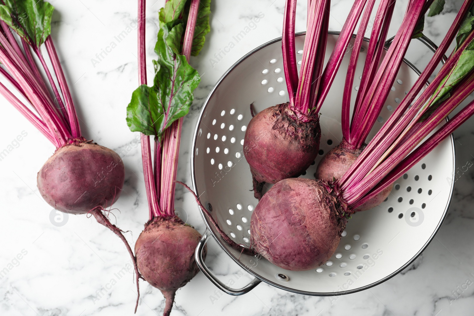 Photo of Raw ripe beets on white marble table, flat lay