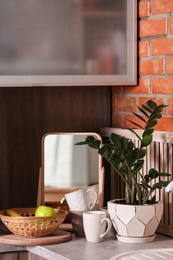 Photo of Small mirror and plant on table in kitchen. Idea for home design