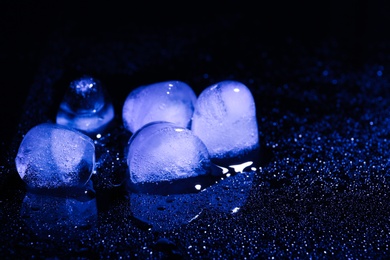 Melting ice cubes on black background. Space for text