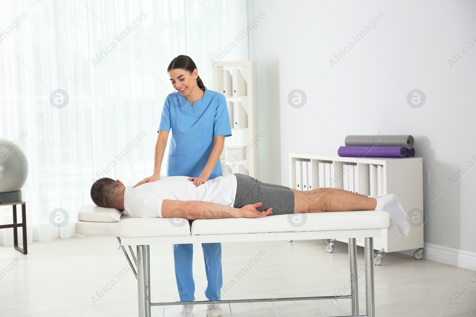 Photo of Doctor working with patient in hospital. Rehabilitation massage