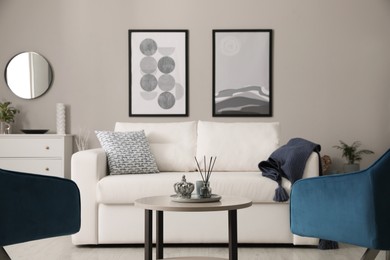 Photo of Stylish living room interior with white sofa, armchairs and small coffee table