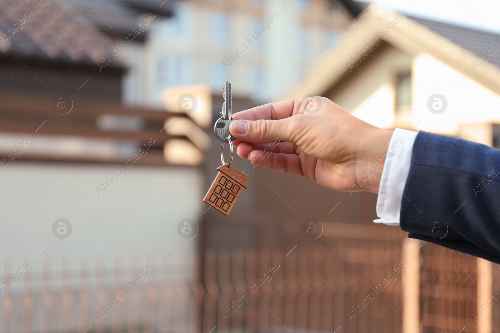 Photo of Real estate agent holding key outdoors, closeup