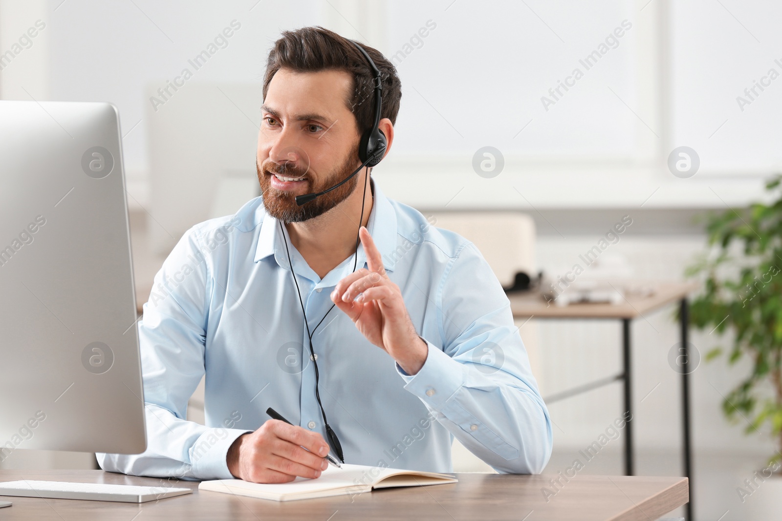 Photo of Hotline operator with headset working in office