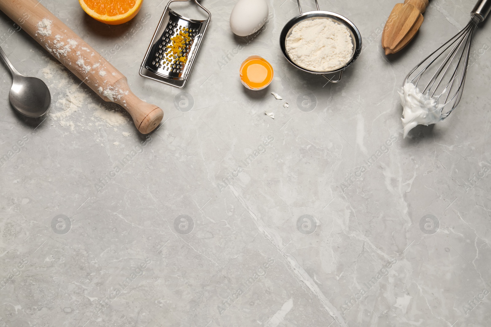 Photo of Flat lay composition with different tools for cooking on light grey marble table. Space for text