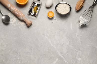 Flat lay composition with different tools for cooking on light grey marble table. Space for text