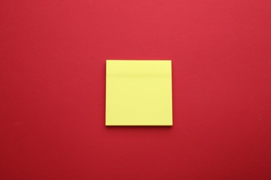 Paper note on red background, top view