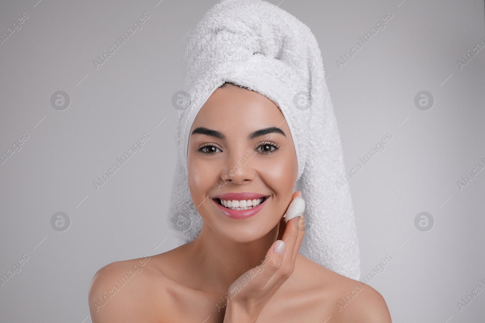 Photo of Woman using silkworm cocoon in skin care routine on light grey background
