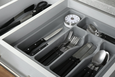 Photo of Open drawer with different utensils. Order in kitchen