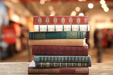Image of Collection of different books on wooden table against blurred background 