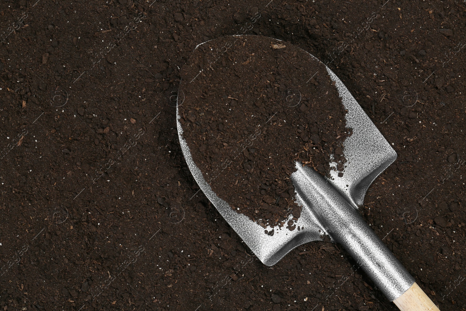 Metal shovel on fertile soil, top view and space for text. Gardening tool Photo of Metal shovel on fertile soil, top view and space for text. Gardening tool