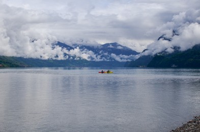 Beautiful landscape with people kayaking on lake in mountains
