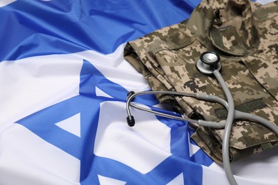 Photo of Stethoscope and military uniform on flag of Israel