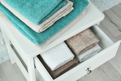 Photo of Small table with clean towels in bathroom