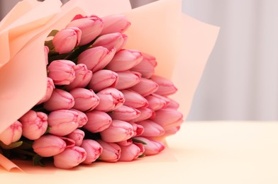 Photo of Bouquet of beautiful pink tulips on beige background, closeup. Space for text