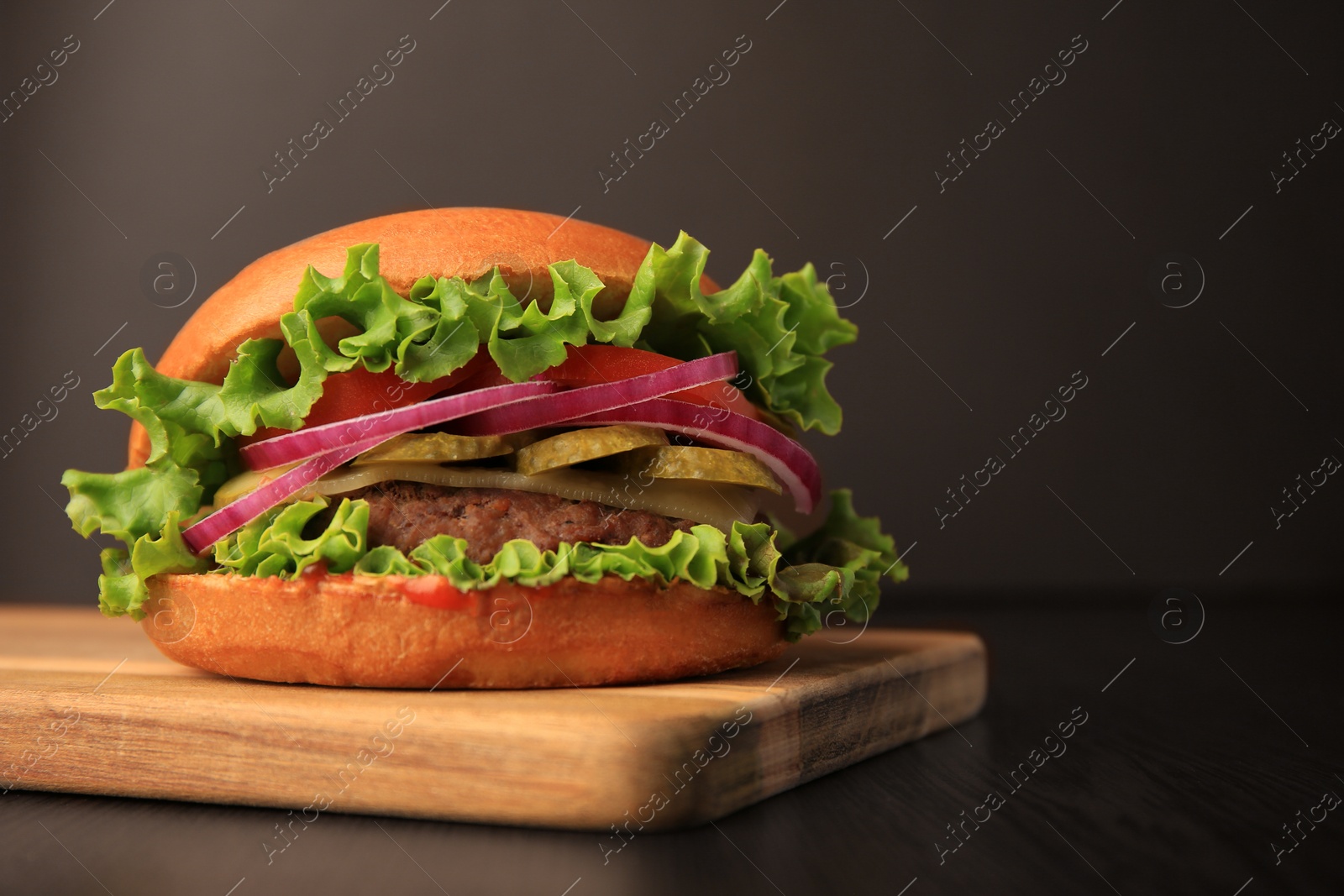 Photo of One tasty burger on wooden table. Space for text